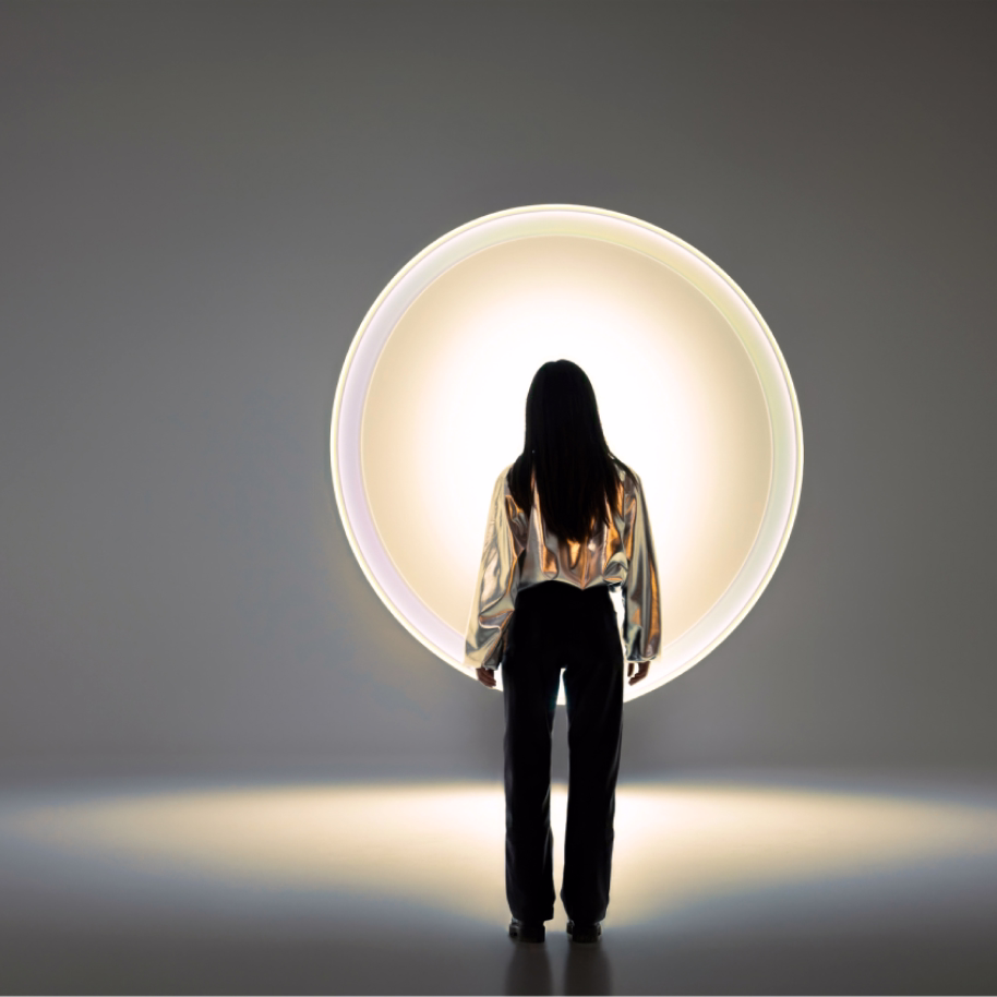 Woman looking at large light for a blog article on choosing a branding agency