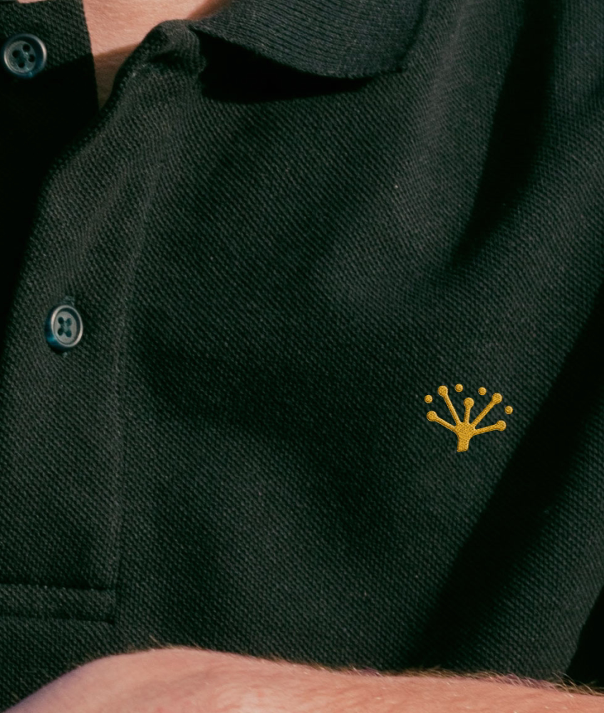 Yarrow logo badge on polo shirt - real estate branding